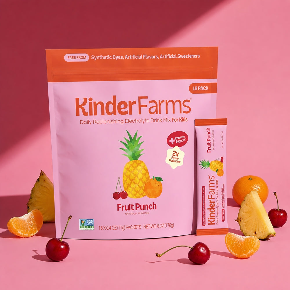 KinderFarms Fruit Punch daily replenishing electrolyte drink mix for kids, shown as a large 10-pack pouch and a single stick pack, styled with fresh fruit slices and whole fruits on a pink background.