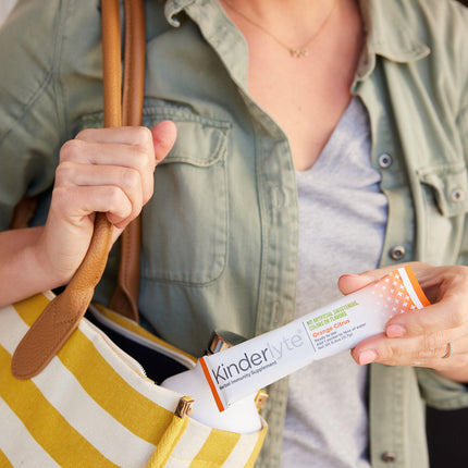 Image of a person pulling a KinderLyte packet out of a bag.